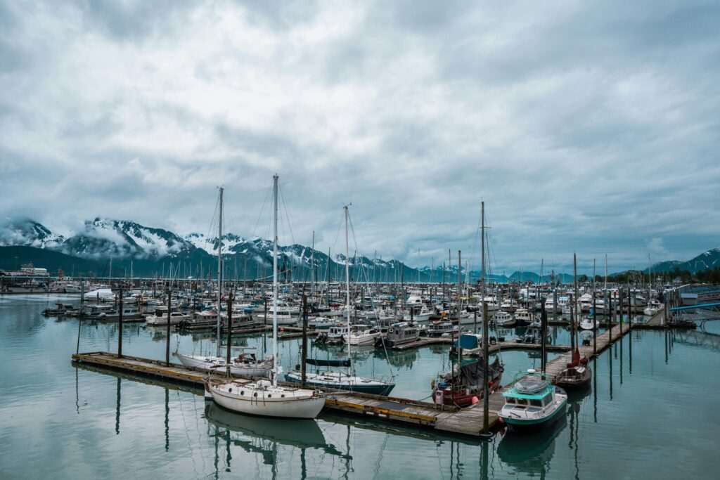 Boats docked in Seward harbor with mountains in the background